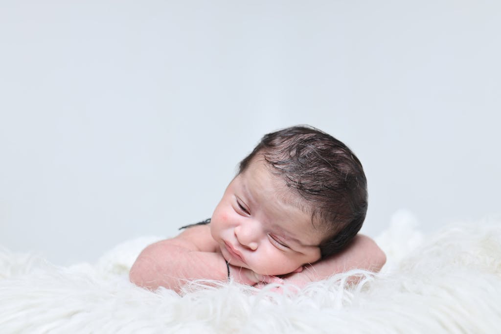 Charming portrait of a sleeping newborn baby on a soft white blanket, radiating innocence and serenity.